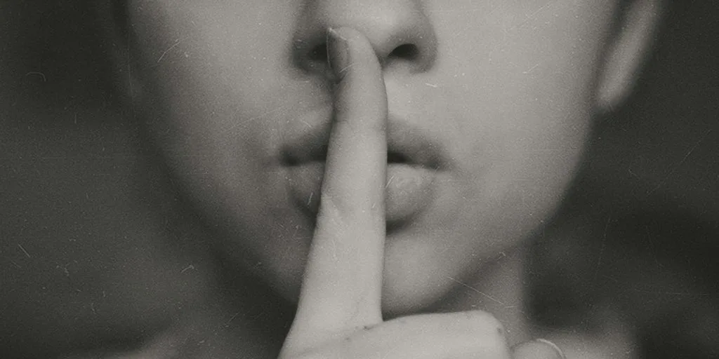 grayscale photo of woman doing silent hand sign