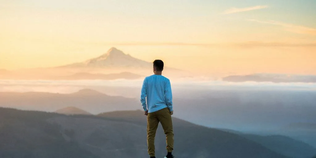 homme sur une montagne regardant l'horizon
