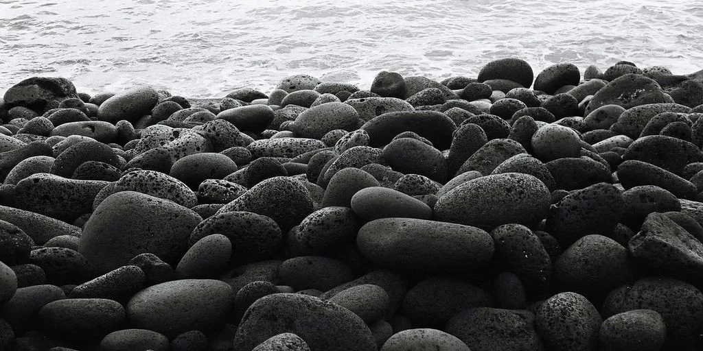 a black and white photo of rocks and water