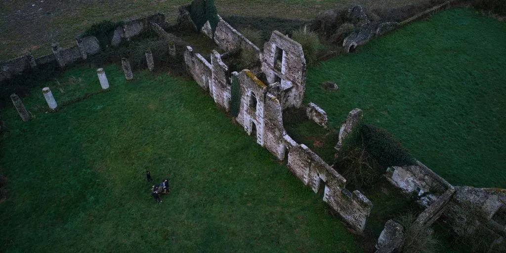 an aerial view of an old building in the middle of a field