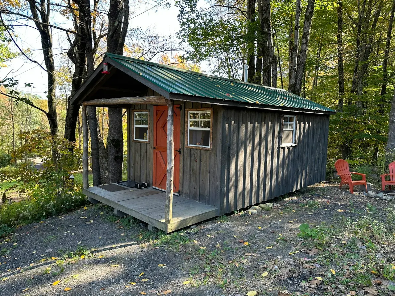 Une cabane en bois située en montagne, entourée d'arbres.