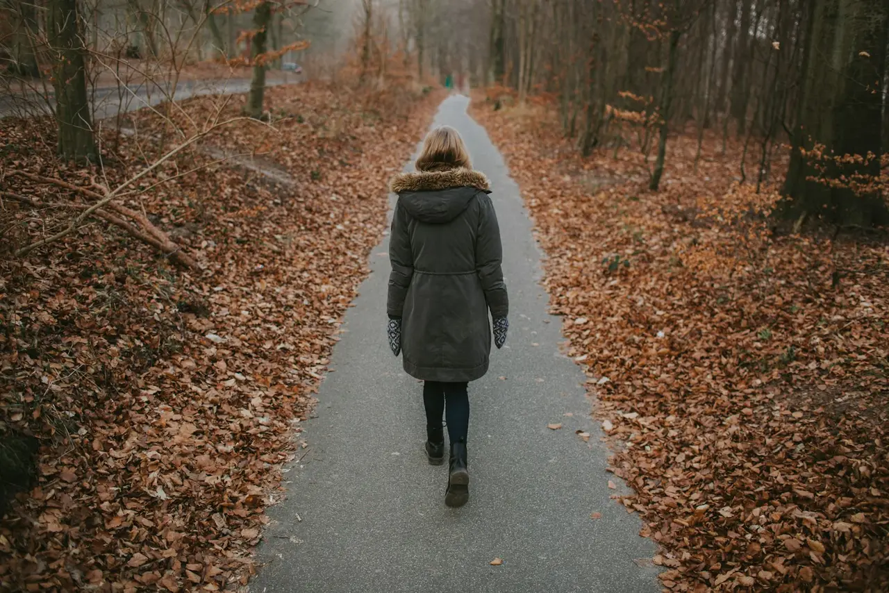 Une personne marchant sur un chemin forestier