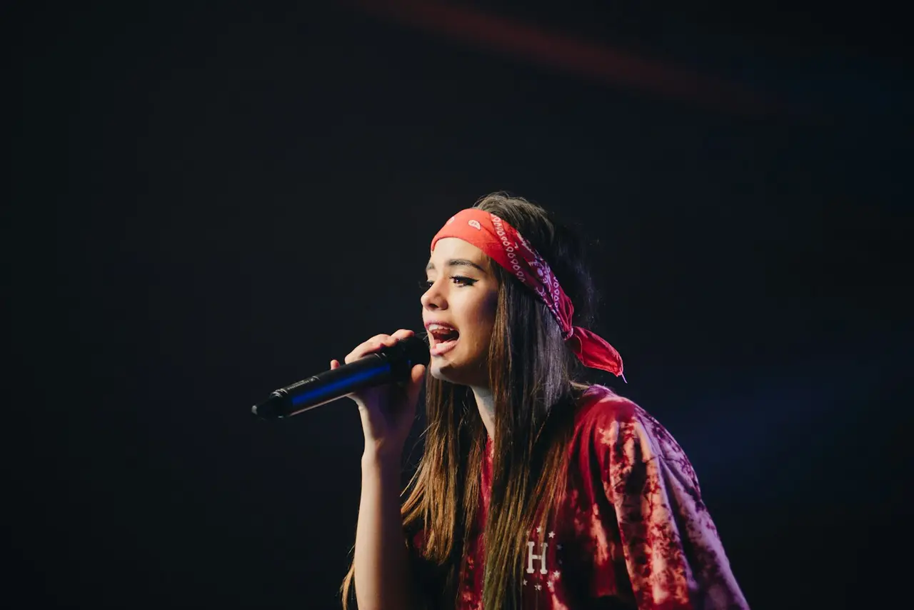 Une chanteuse sur scène, exprimant des vibrations vocales.