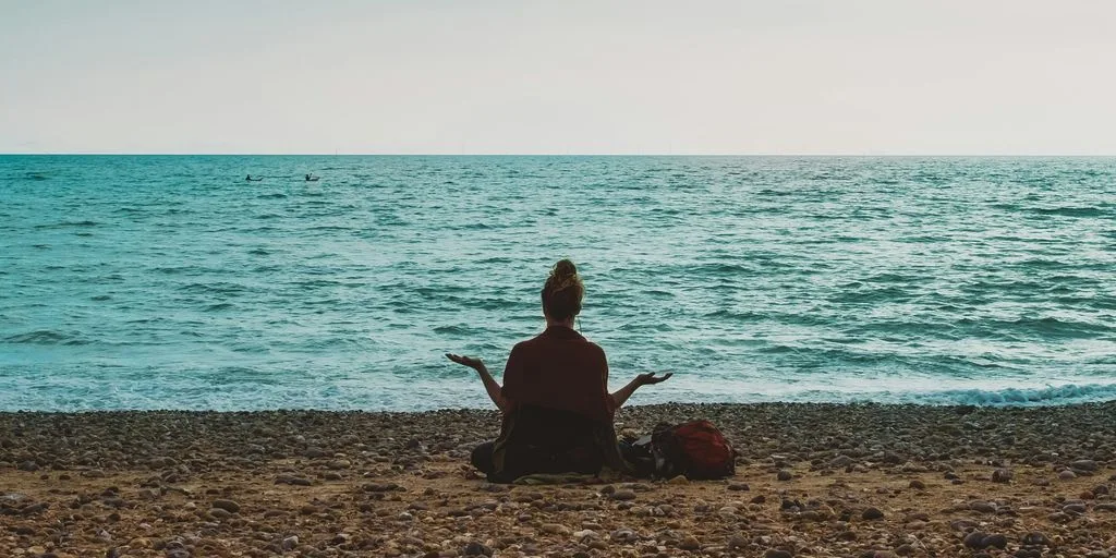 person doing yoga on seashore during daytime